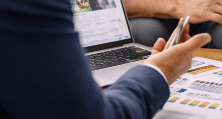 Agent immobilier analysant des documents sur ordinateur